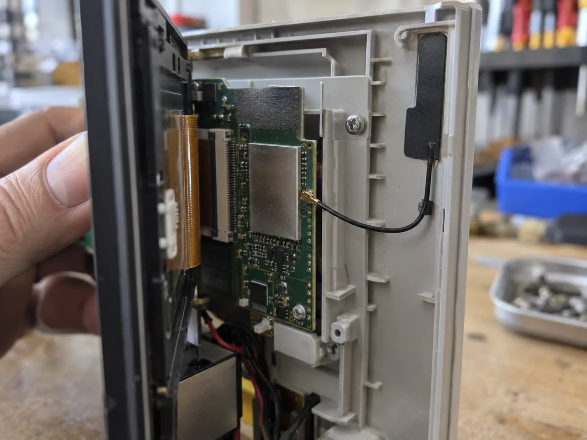 Conceptual open control-panel enclosure with a coax lead to a flexible antenna mounted along the plastic edge, away from a metal shield