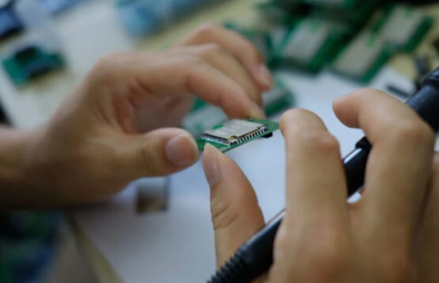 Engineer inspecting a connected hardware module during prototype validation